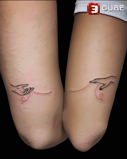 Minimalist couple tattoo of interlocking hands with red string at 3cube tattoo studio Kolkata, representing the bond and connection between couples.